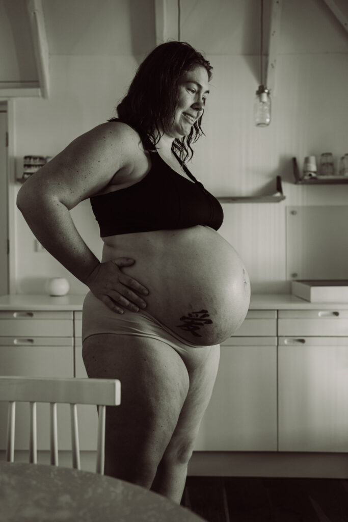 Geboortefotograaf Ede , barende vrouw vangt wiegend weeën op in de keuken