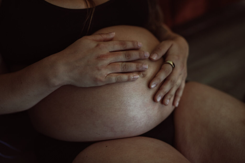 Zwangerschapsreportage – vrouw met handen op buik tijdens Waiting Days sessie