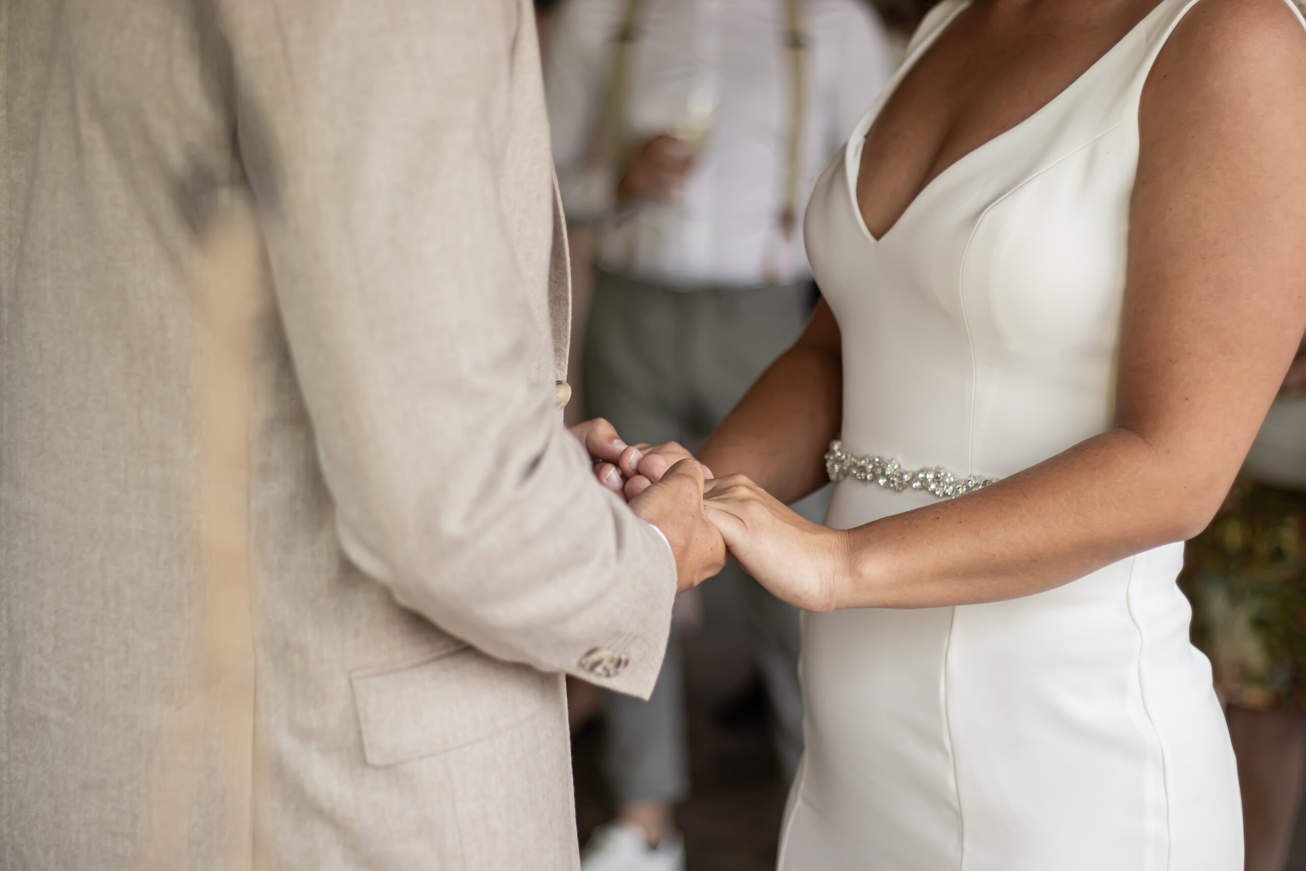 Bruid en bruidegom houden elkaars handen vast tijdens de ceremonie